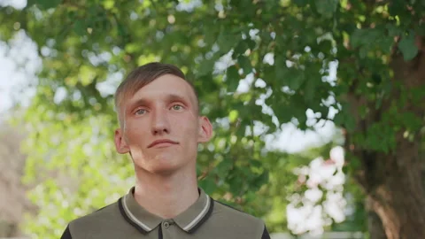Caucasian Man Adjusting Sunglasses While Looking Skyward, Framed By Leafy Canopy Video stock 324614527