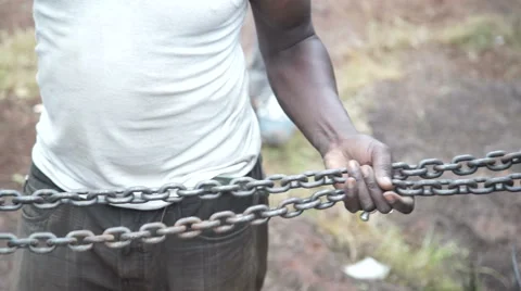 A Caucasian man and an African pulling a chain. Video on collaboration, work Stock Footage 67411031