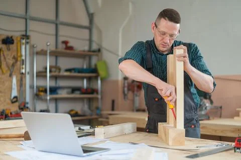Caucasian man assembling a table with a screwdriver. Stock Photos