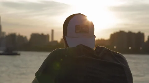 Caucasian man back view with a white cap looking at New York City from Brooklyn. Vídeos de archivo 110771216