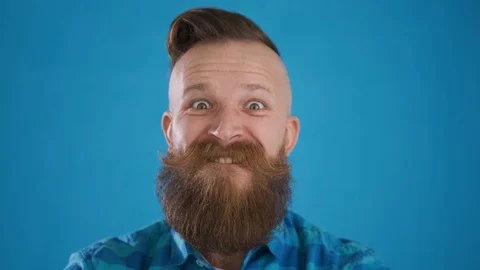 Caucasian man with beard and mustache in blue shirt looks at camera, shows fuck Stock Footage 127625053