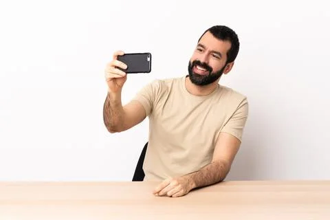 Caucasian man with beard in a table making a selfie Stock Photos