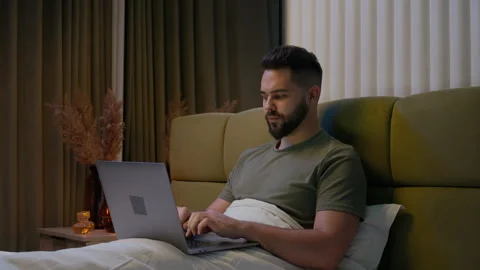 Caucasian man bed remote working laptop typing home computer gadget businessman Vídeos de archivo 285685666