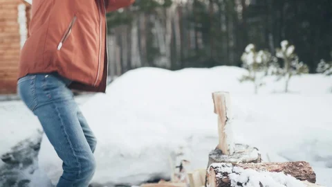 A Caucasian man in a brown jacket, hat, jeans and boots, holding an axe Stock Footage 128005173