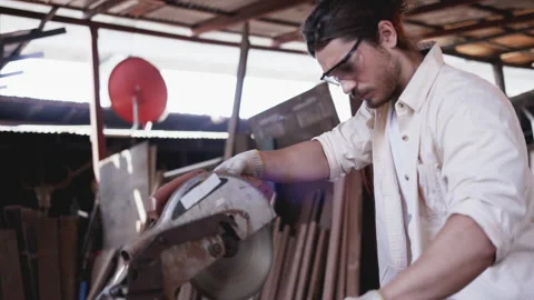 Caucasian man carpenter working with machine Or electric wood saw in wood Stock Footage 147603796