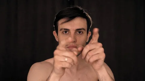 Caucasian man dancing funny in front of the camera, on a black background Video stock 128914085