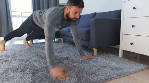Caucasian man does exercise at home during quarantine due to COVID-19 Stock Footage 129891282