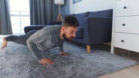 Caucasian man does push ups at home during quarantine due to COVID-19 Stock Footage 129891165