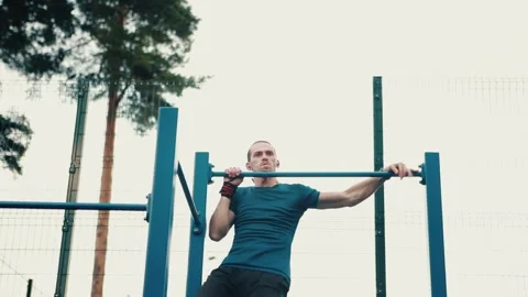 Caucasian man doing pull-ups on the horizontal bar, exercising on the outdoor Stock Footage 149754836