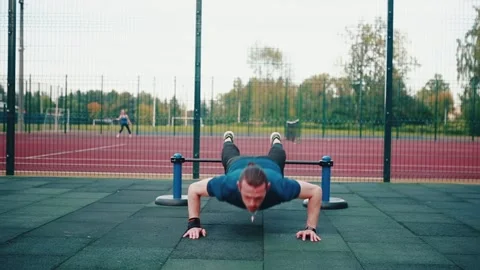 Caucasian man doing push-ups, exercising on the outdoor sports ground. Stock Footage 149749949