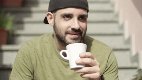 Caucasian man drinks a cup of tea for break or breakfast. Day light, front view Stock Footage 149112005