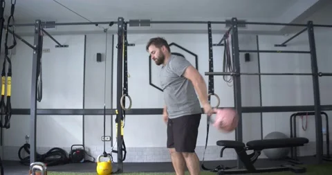 Caucasian man exercising in a gym practicing Kettlebell Stock Footage 186502097