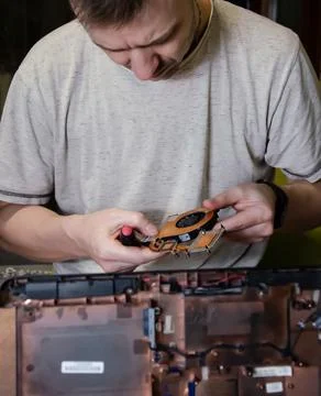Caucasian man fixing computer. Self-repair concept. Disassembled laptop. Stock Photos