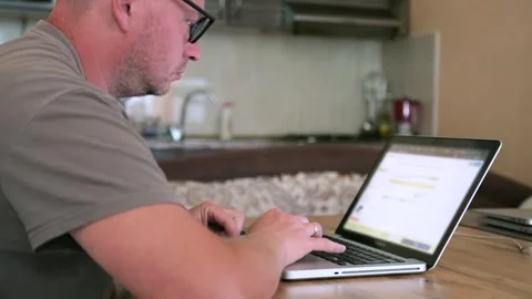 Caucasian man with glasses writes program code on laptop, close up. Stock Footage 243580550