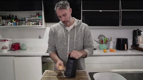 A caucasian man grating cheese in the modern kitchen Stock Footage 279999098