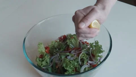 Caucasian man hand  squeezing lemon on fresh salat Stock Footage 159549330