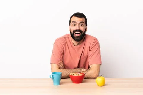 Caucasian man having breakfast in a table with surprise facial expression Stock Photos