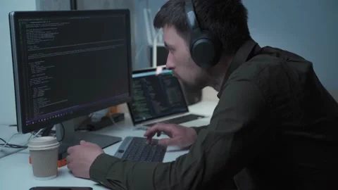 Caucasian man in headphones IT coder programmer software engineer use laptop Stock Footage 153499411