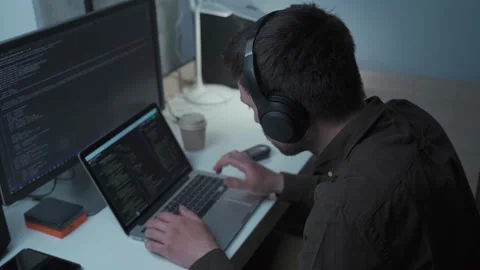 Caucasian man in headphones IT coder programmer software engineer use laptop Stock Footage 153499945