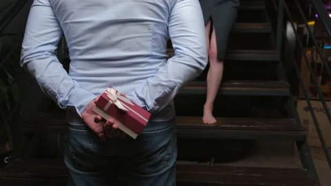 Caucasian man is hiding a present behind his back waiting for his lover on Stock Footage 148103246
