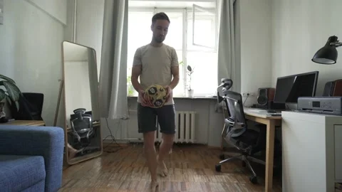 Caucasian man kicking the ball while on self-isolation during a pandemic Stock Footage 134406447
