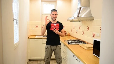 Caucasian man in the kitchen showing a fire extinguisher for home safety 스톡 동영상 122201627