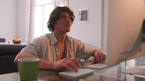 Caucasian man at kitchen table reacting to screen, sudden expression of surprise Stock Footage 331281060