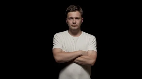Caucasian man looking at camera with arms folded. Black isolated Stock Footage 110994642