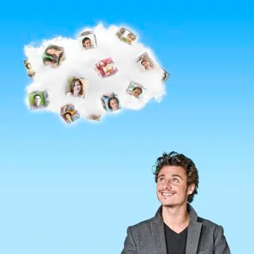 Caucasian man looking at cloud containing cubes with pictures of people Stock Photos