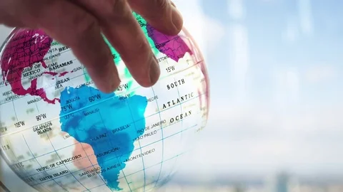 A caucasian man looking at a transparent globe backlit by the sun Video stock 85108975