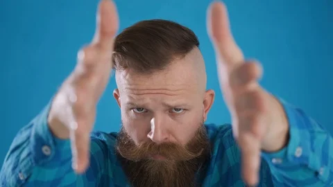 Caucasian man looks at camera dancing moves his hands,on a blue background Stock Footage 127624814
