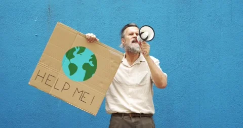 Caucasian man with a megaphone protesting climate change on a blue wall Stock Footage 157809282