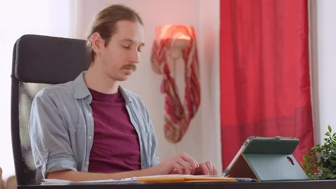 A caucasian man performs neck exercises while working from home - slow motion Stock Footage 129956773