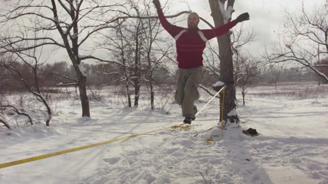 Caucasian man practicing slackline in the winter forest. 스톡 동영상 147155155
