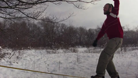 Caucasian man practicing slackline in the winter forest. 스톡 동영상 147159694