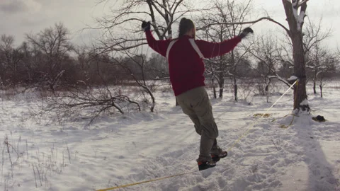 Caucasian man practicing slackline in the winter forest. 스톡 동영상 147159710