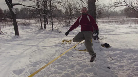 Caucasian man practicing slackline in the winter forest. 스톡 동영상 147159903