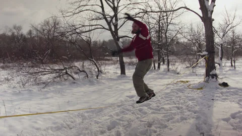 Caucasian man practicing slackline in the winter forest. 스톡 동영상 147159967