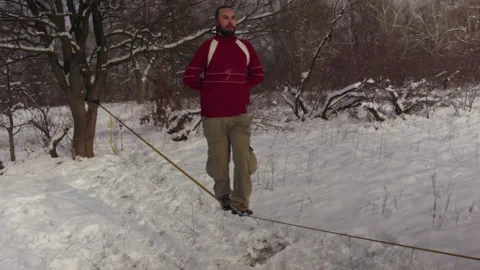 Caucasian man practicing slackline in the winter forest. 스톡 동영상 147160778