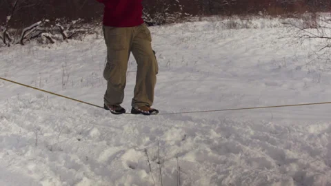 Caucasian man practicing slackline in the winter forest. 스톡 동영상 147160952