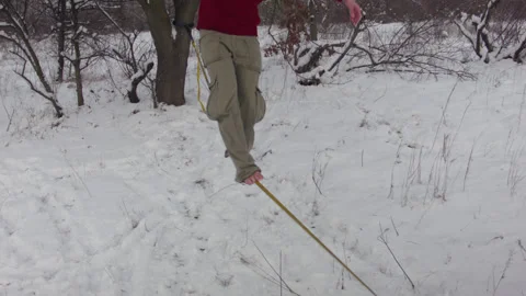 Caucasian man practicing slackline in the winter forest. 스톡 동영상 147161937