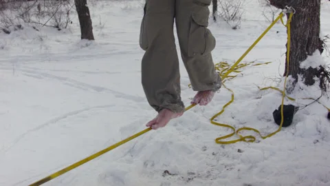 Caucasian man practicing slackline in the winter forest. 스톡 동영상 147162157