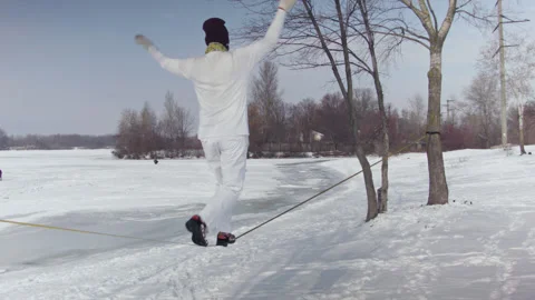 Caucasian man practicing slackline in the winter forest. Stock Footage 148168831