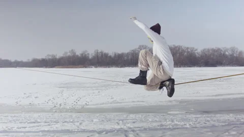 Caucasian man practicing slackline in the winter forest. Stock Footage 148170120