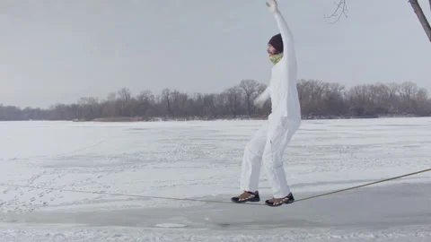 Caucasian man practicing slackline in the winter forest. Stock Footage 148170262