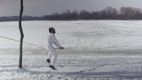 Caucasian man practicing slackline in the winter forest. Stock Footage 148285228