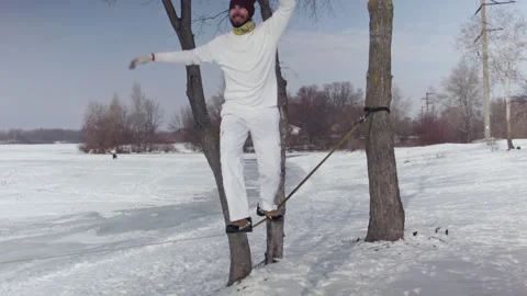 Caucasian man practicing slackline in the winter forest. Stock Footage 148286284