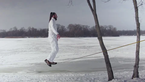 Caucasian man practicing slackline in the winter forest. Stock Footage 148286455