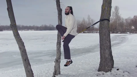 Caucasian man practicing slackline in the winter forest. Stock Footage 148300009