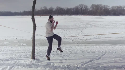 Caucasian man practicing slackline in the winter forest. Stock Footage 148300644